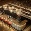 vintage curved onyx stone bar counter with arched metal wine rack for retro restaurant and whiskey lounge