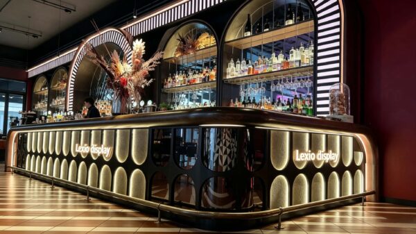 art deco illuminated curved bar counter with oval backlit panels and arched wine shelving for cocktail lounge speakeasy