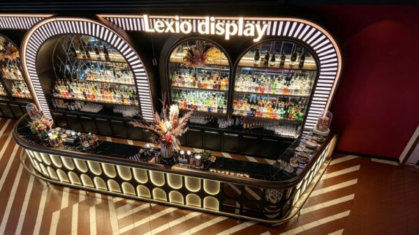 art deco illuminated curved bar counter with oval backlit panels and arched wine shelving for cocktail lounge speakeasy