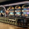 art deco illuminated curved bar counter with oval backlit panels and arched wine shelving for cocktail lounge speakeasy