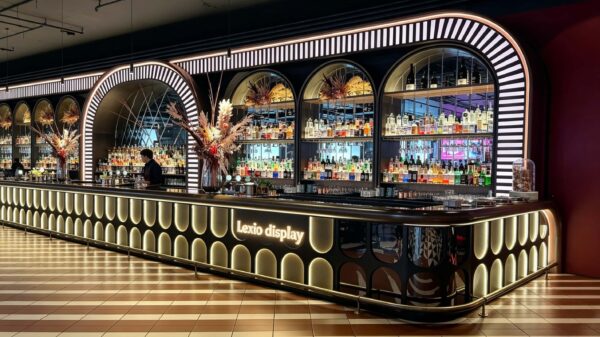 art deco illuminated curved bar counter with oval backlit panels and arched wine shelving for cocktail lounge speakeasy