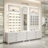 Custom Full White Modular Eyewear Wall Display System | LED Lit Multi-Style Optical Frame & Sunglasses Display Wall With Central Mirror, Large Drawer Storage Base & Decor Niche Shelves For Optical Shop Interior Design