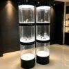 column display cabinet (7) Wholesale 3-Section Segmented Cylindrical LED Display Tower | Gloss Black Trim Freestanding Round Showcase for Watch & Jewelry Boutique Store