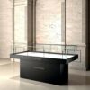 Matte black low island glass display case with white interior and built-in spotlights Lexio Display for museum artifacts, jewelry and luxury goods exhibition