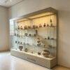 museum display cabinet (12) Long wall‑back museum glass display case with adjustable shelves and recessed top LED lighting Lexio Display for gallery artifact exhibition