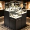 museum display cabinet (16) Staggered multi-tier frameless glass jewelry island display cabinet with matte dark base Lexio Display for luxury jewellery boutique retail