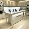 phone display cabinet (29) Slant top glass display counter with tapered high legs built‑in LED lighting custom metal logo Lexio Display for electronics retail