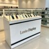 White floor standing mobile phone glass display counter with black stripes LED slanted showcase brand logo panel Lexio Display
