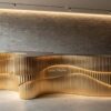 Custom layered vertical fluted gold irregular wavy reception desk luxury lobby counter Lexio Display