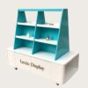 Mobile teal white trapezoidal multi-tier retail display cart with storage cabinet and caster wheels Lexio Display for cosmetic perfume boutique mall pop-up