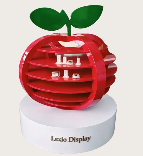 Gloss red creative apple shaped multi-tier retail display stand with green leaf decoration white round base Lexio Display for cosmetic beverage mall pop-up showcase