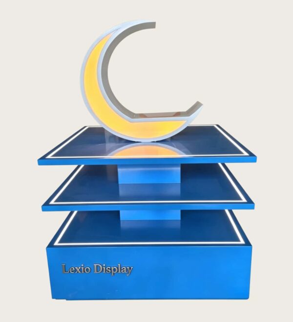 Blue three-tier LED edge lighted retail island display stand with illuminated crescent decor Lexio Display for shopping mall pop-up and product promotion