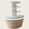 Four-tier round retail display stand wood grain tapered base with warm LED lighting white shelves Lexio Display for café bakery and mall food retail