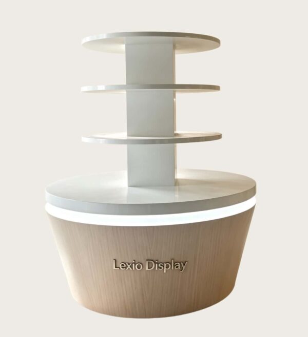 Four-tier round retail display stand wood grain tapered base with warm LED lighting white shelves Lexio Display for café bakery and mall food retail