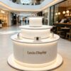 Light blue white three-tier cylindrical LED glowing retail island display stand Lexio Display for electronics cosmetic boutique and mall pop-up showcase