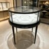 retail display stands (7) Round glass top jewelry display showcase black metal frame tapered legs white velvet interior Lexio Display for luxury jewellery boutique retail