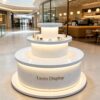 Light blue white three-tier cylindrical LED glowing retail island display stand Lexio Display for electronics cosmetic boutique and mall pop-up showcase