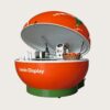Giant orange‑shaped fiberglass mobile juice vending cart with hydraulic lifting dome lid and leaf sculpture, fruit themed kiosk with wheels Lexio Display