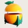 Giant orange‑shaped fiberglass mobile juice vending cart with hydraulic lifting dome lid and leaf sculpture, fruit themed kiosk with wheels Lexio Display