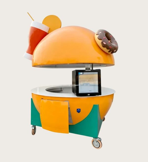 Giant burger‑shaped fiberglass mobile food vending cart, hydraulic lift dome top with donut and drink decorative sculptures, amusement park themed snack kiosk Lexio Display