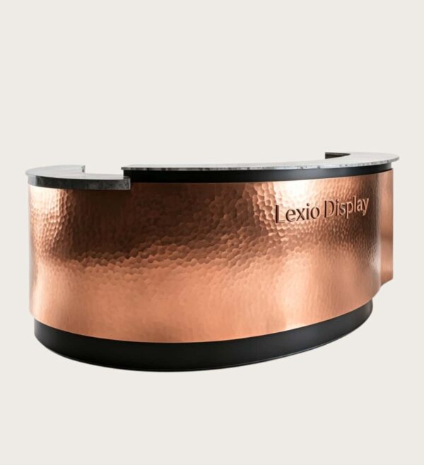 U‑shape semi‑circular reception desk with hand hammered copper cladding and natural granite stone top, curved luxury lobby front counter Lexio Display for premium hospitality interior fit‑out