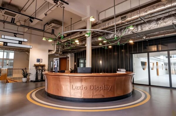 U‑shape curved reception desk with vertical panel aged patina copper cladding, vintage industrial‑style lobby front counter Lexio Display for loft and commercial space