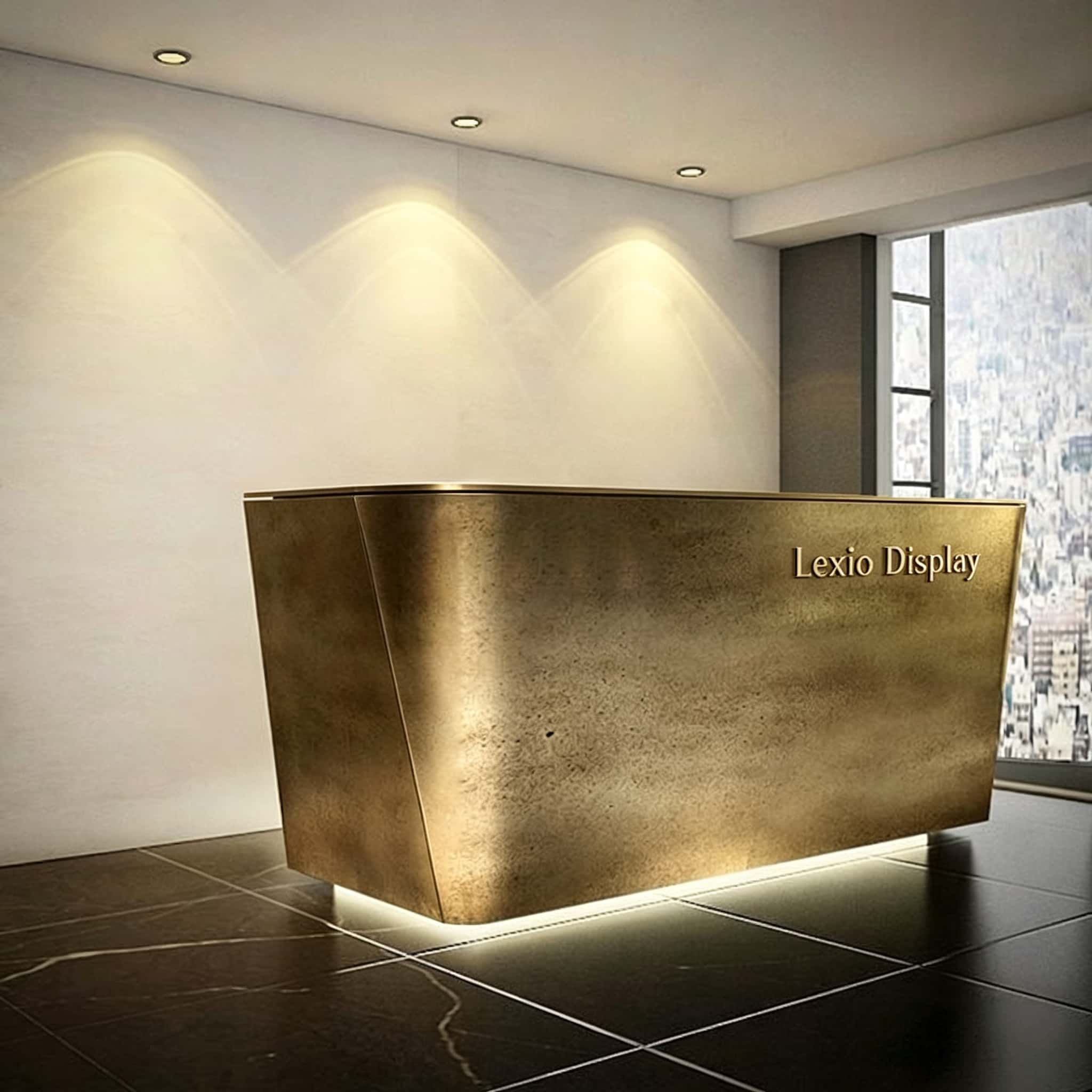 Chamfered angular reception desk with textured forged aged brass metal cladding, floating base LED glow luxury office lobby front desk Lexio Display for premium commercial fit‑out