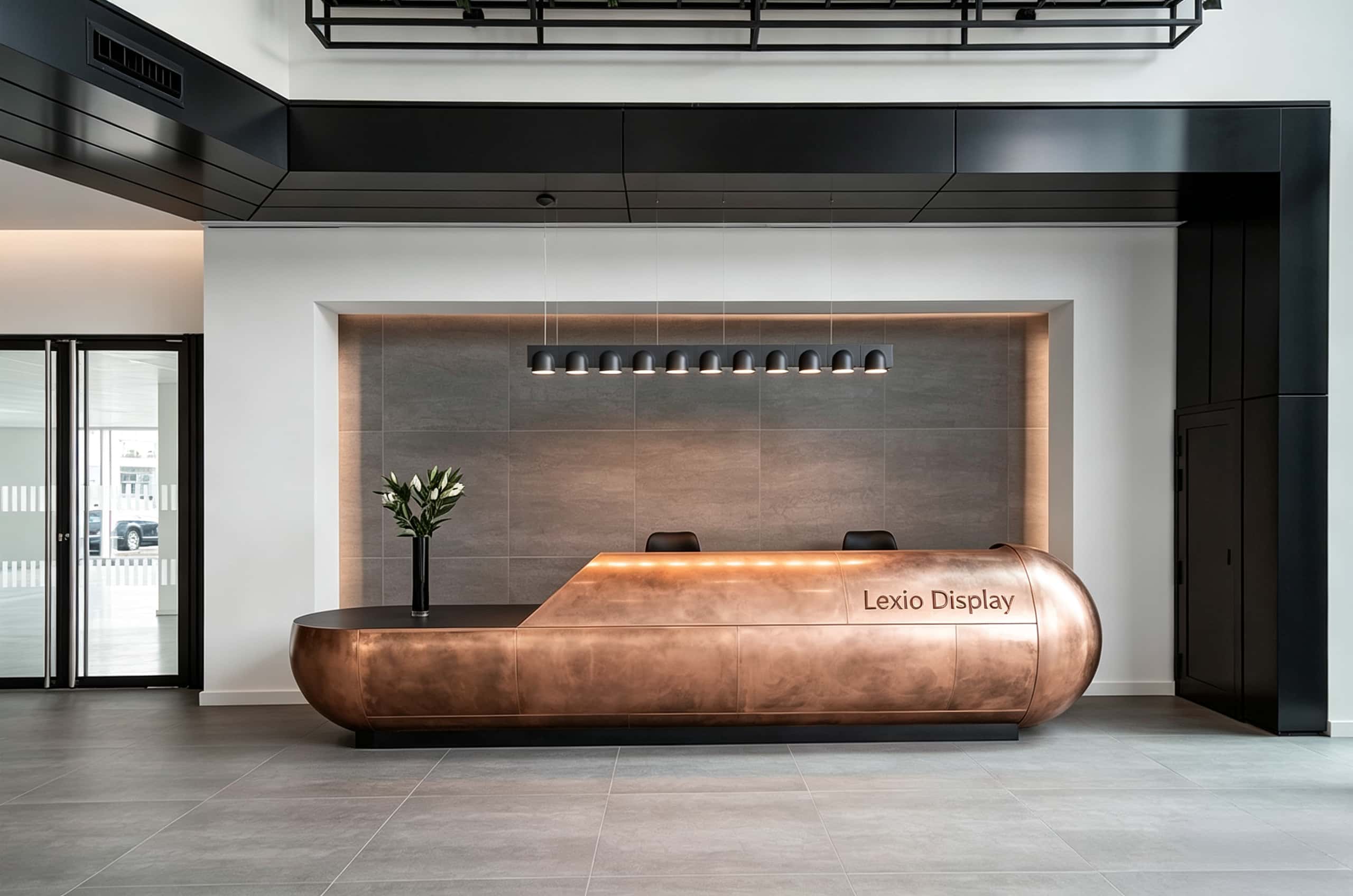 Sculptural capsule‑shaped aged copper reception desk with rounded bulbous ends and integrated top LED strip, large luxury lobby front desk Lexio Display for high‑end commercial fit‑out