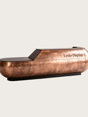 Sculptural capsule‑shaped aged copper reception desk with rounded bulbous ends and integrated top LED strip, large luxury lobby front desk Lexio Display for high‑end commercial fit‑out