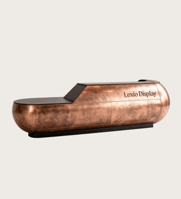 Sculptural capsule‑shaped aged copper reception desk with rounded bulbous ends and integrated top LED strip, large luxury lobby front desk Lexio Display for high‑end commercial fit‑out