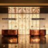 Hammered bronze curved luxury reception desk, solid metal hotel lobby front counter by Lexio Display for high‑end commercial interior