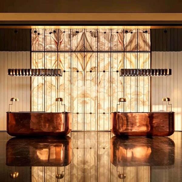Hammered bronze curved luxury reception desk, solid metal hotel lobby front counter by Lexio Display for high‑end commercial interior