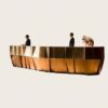 Large geometric faceted metal‑panel multi‑person reception desk, luxury hotel lobby front counter Lexio Display for high‑end commercial interior