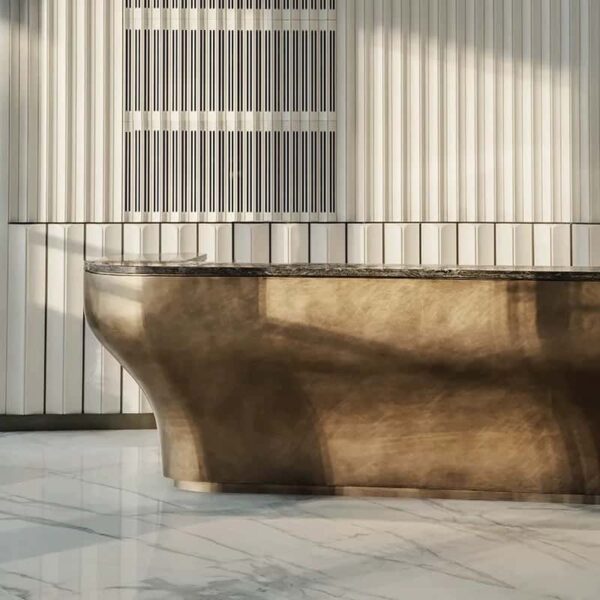 Brushed bronze curved reception desk with natural marble top, solid‑body luxury lobby counter Lexio Display for premium hotel and corporate project