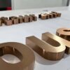 Thin brushed bronze metal letters with mounting studs for wall installation