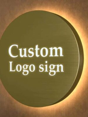 Close-up view of circular gold backlit metal sign with illuminated custom logo letters