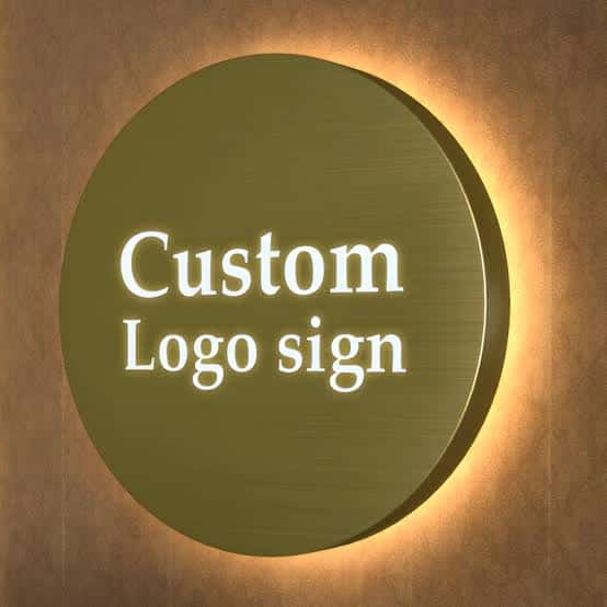 Close-up view of circular gold backlit metal sign with illuminated custom logo letters