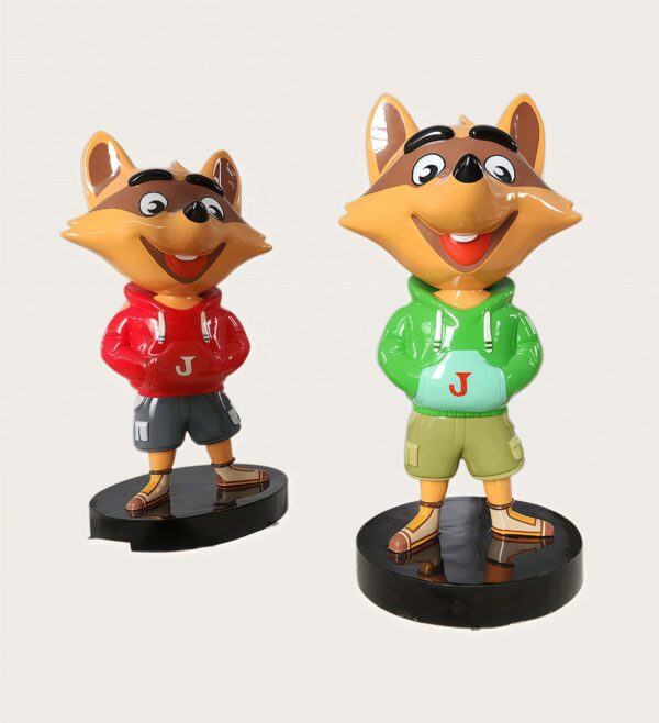Factory workshop photo of two cartoon raccoon fiberglass mascot sculptures, red hoodie and green hoodie raccoon characters standing on black round bases