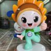 Customized fiberglass display (8) Spray workshop photo of sunflower cartoon fiberglass mascot sculpture, big orange sunflower petal head, mint green suit, thumbs-up pose on white round base
