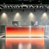 Red-orange glowing LED reception table, custom studio lobby front desk with metal frame