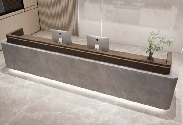 Top angled view modern stone veneer reception desk, grey marble texture front panel, dark wood top with bottom LED strip lighting for corporate lobby