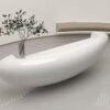 reception desk (3) Side view modern oval fiberglass reception counter, high gloss white surface displayed in minimalist plain showroom