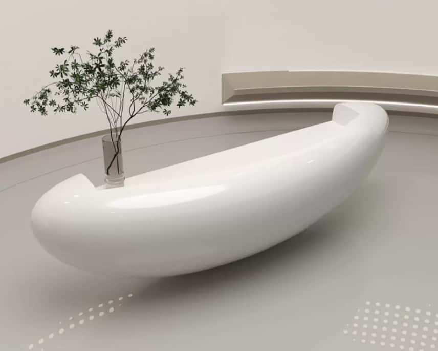 Side view modern oval fiberglass reception counter, high gloss white surface displayed in minimalist plain showroom