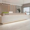 reception desk (4) Wide shot minimalist white reception desk inside bright contemporary office lobby with pendant lighting and green plants