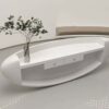 reception desk (5) Isolated view sculptural organic curved white fiberglass reception desk, smooth glossy finish with plant vase on countertop