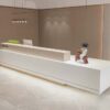 reception desk (6) Full front view of matte white modern reception counter with wood grain top barrier and hidden warm LED base lighting